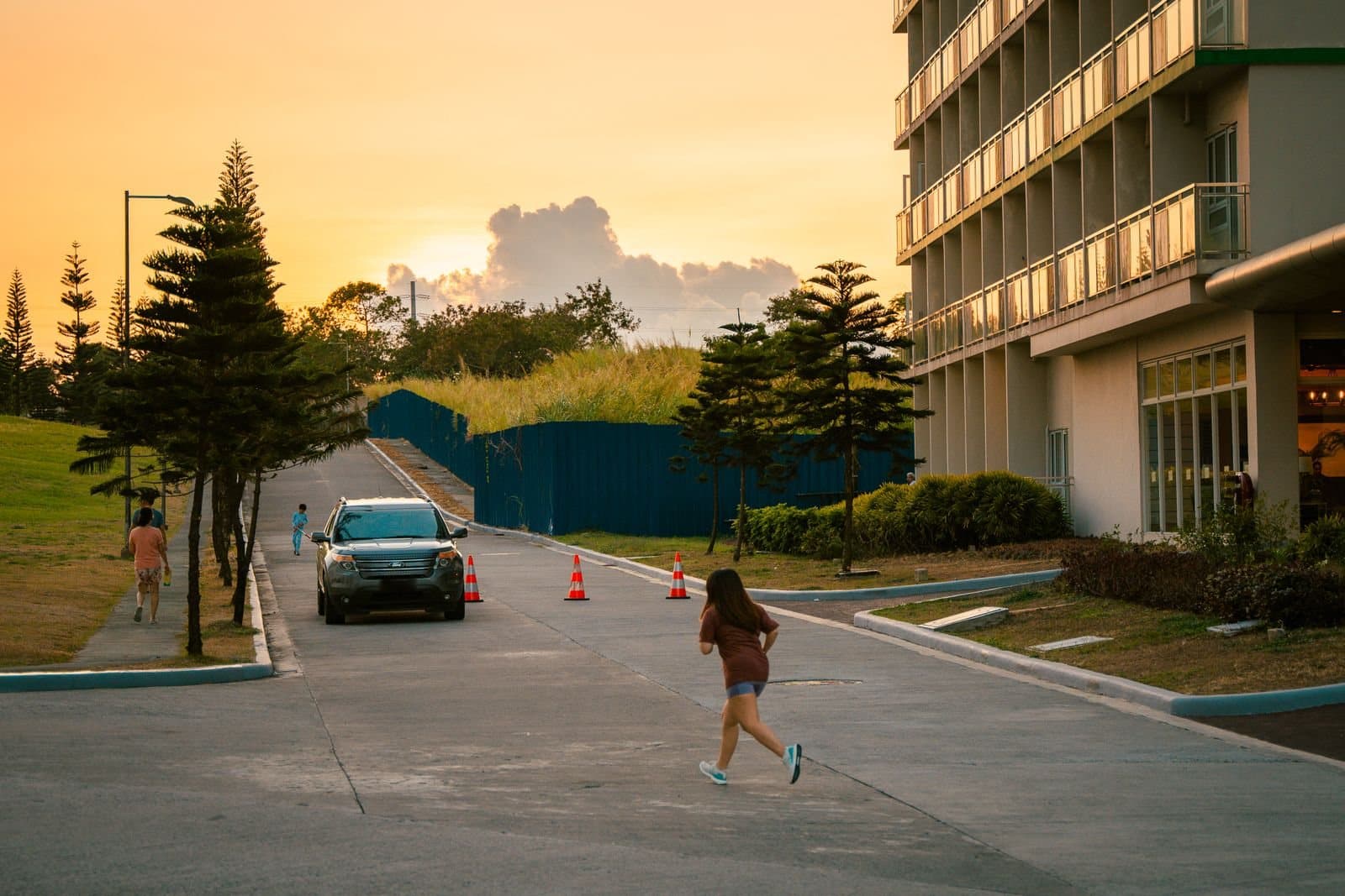 A runner on a quiet road at sunset heads toward a parked SUV — the kind of situation runners notice first.